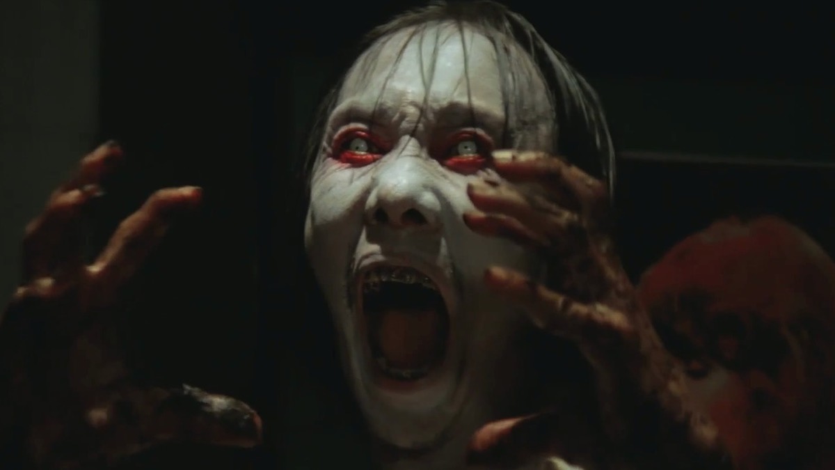 Hantu perempuan berwajah pucat menjerit dalam gelap, still dari Pengabdi Setan (1980)